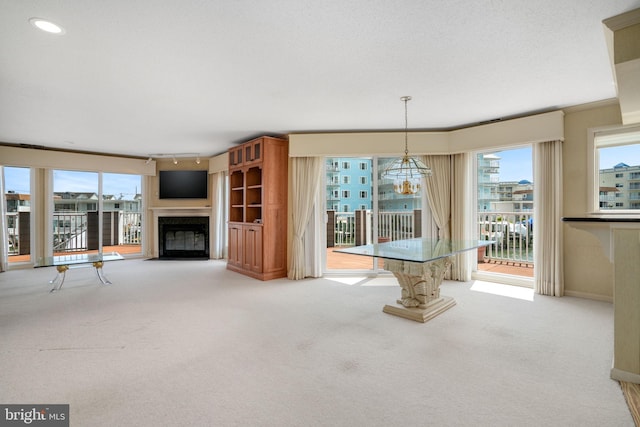 415 14th St Unit 55A, Ocean City, MD 21842 - unfurnished living room with light carpet, a fireplace with flush hearth, a chandelier, and plenty of natural light