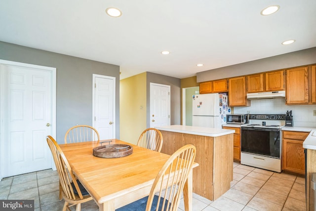 kitchen featuring white appliances, light tile patterned flooring, decorative backsplash, light countertops, and under cabinet range hood