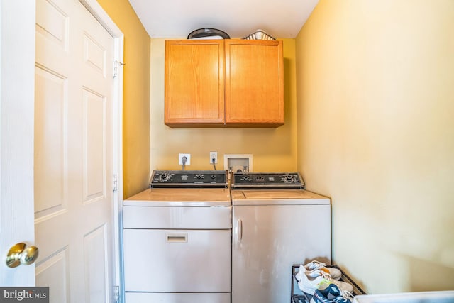 clothes washing area with washer and dryer and cabinet space