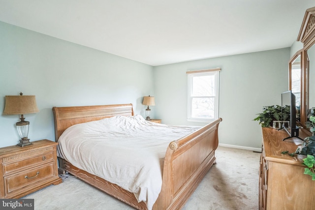 bedroom with light colored carpet and baseboards