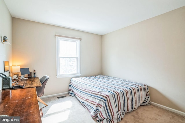 carpeted bedroom featuring visible vents and baseboards