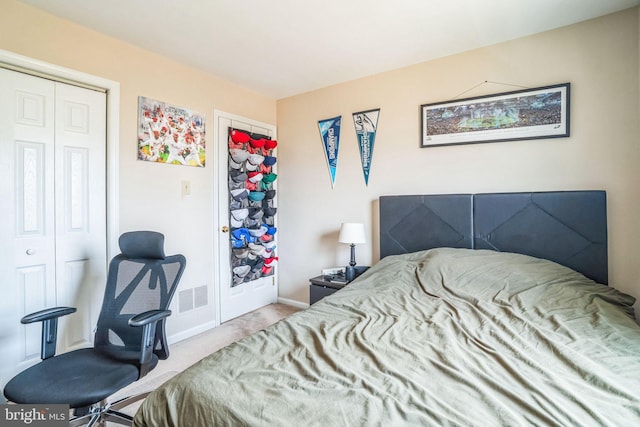 carpeted bedroom featuring a closet, visible vents, and baseboards