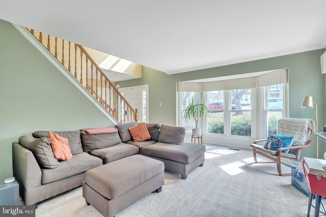 living room with light carpet, crown molding, and stairs