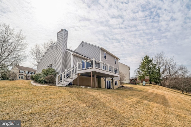 rear view of house with a chimney, stairway, a lawn, and a wooden deck