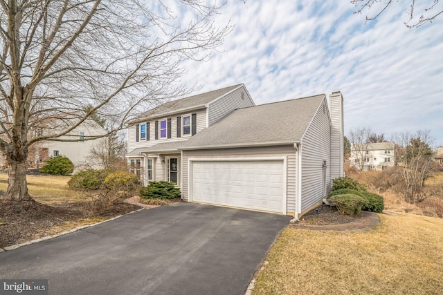 view of front of house with driveway, a shingled roof, a chimney, a front lawn, and a garage