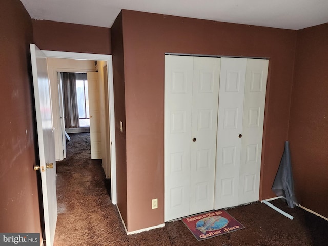 unfurnished bedroom with a closet and carpet floors