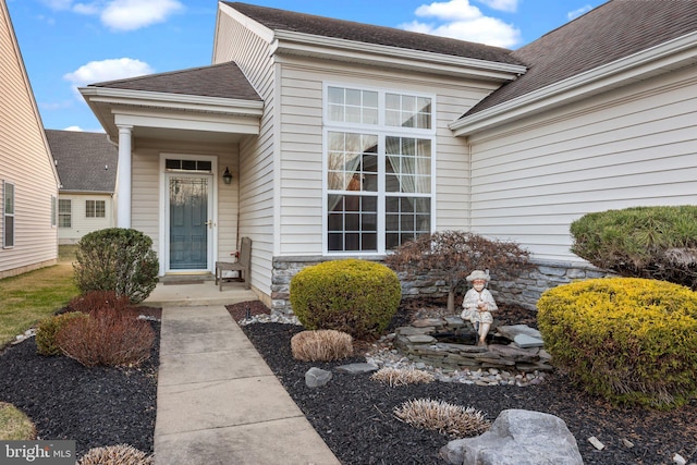 property entrance with roof with shingles