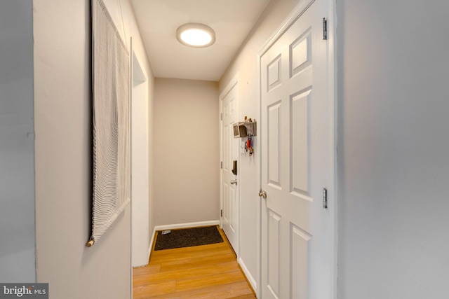 hall with light wood finished floors and baseboards