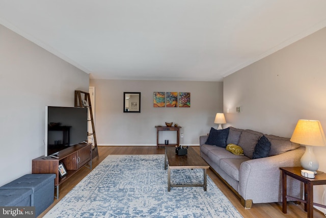 living room with baseboards, wood finished floors, and crown molding