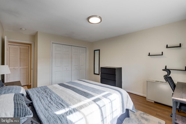 bedroom featuring a closet, baseboards, and wood finished floors