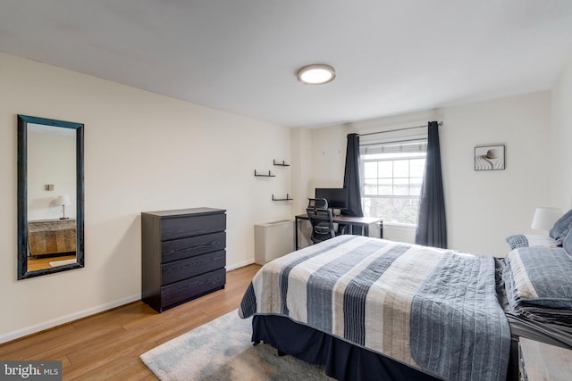 bedroom with baseboards and wood finished floors