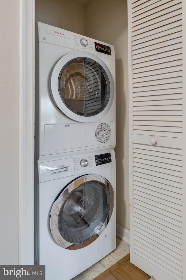 laundry room with stacked washer and dryer and laundry area