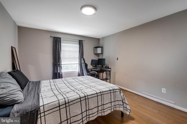 bedroom with baseboards and wood finished floors