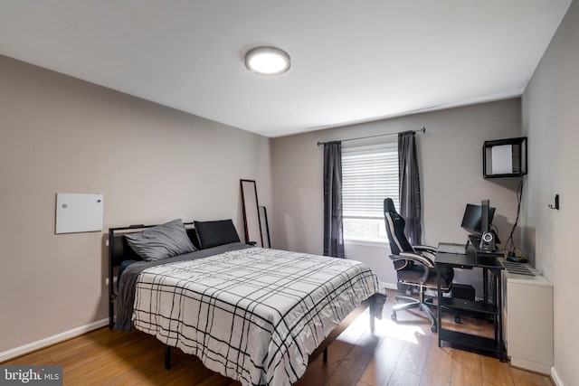 bedroom with wood finished floors and baseboards