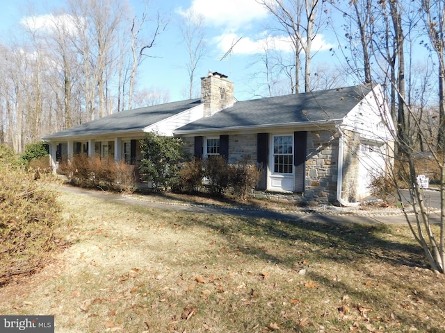 ranch-style home featuring a front yard, a garage, stone siding, and a chimney