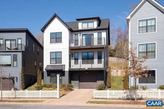 view of front facade with a balcony, board and batten siding, concrete driveway, and fence