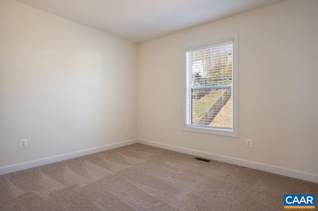 carpeted spare room with baseboards and visible vents