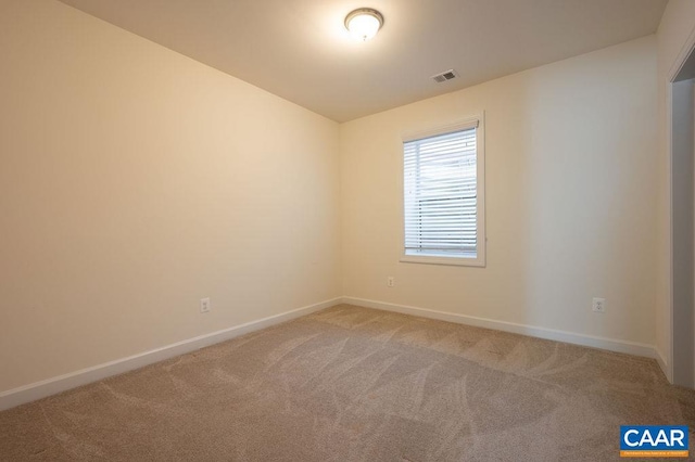 unfurnished room featuring visible vents, light carpet, and baseboards