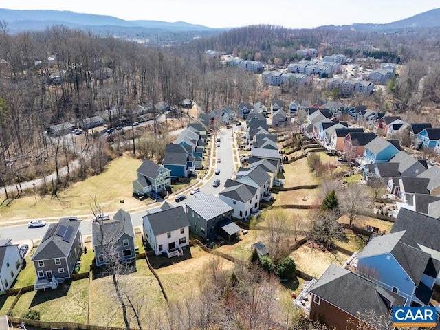 drone / aerial view featuring a wooded view, a mountain view, and a residential view