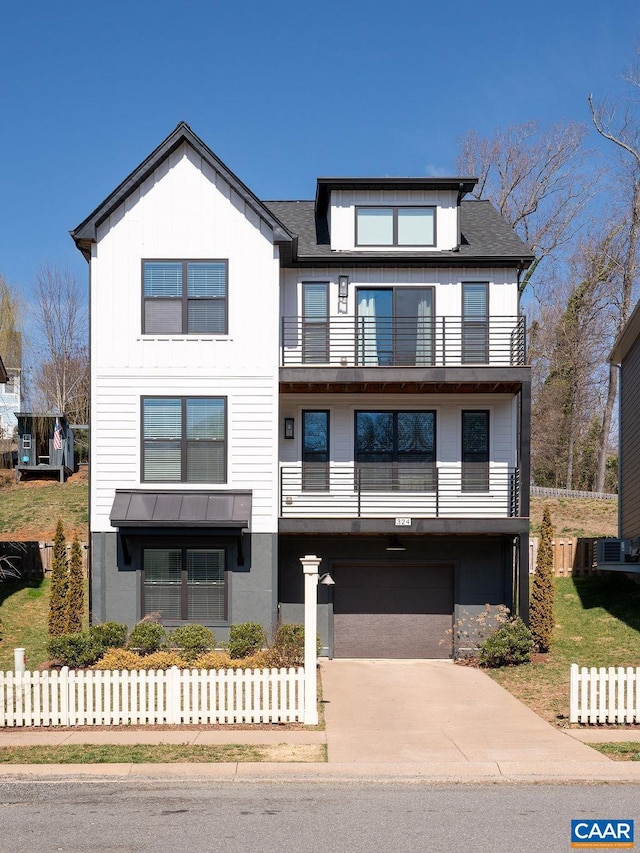 view of front of house featuring concrete driveway, a balcony, fence, and board and batten siding