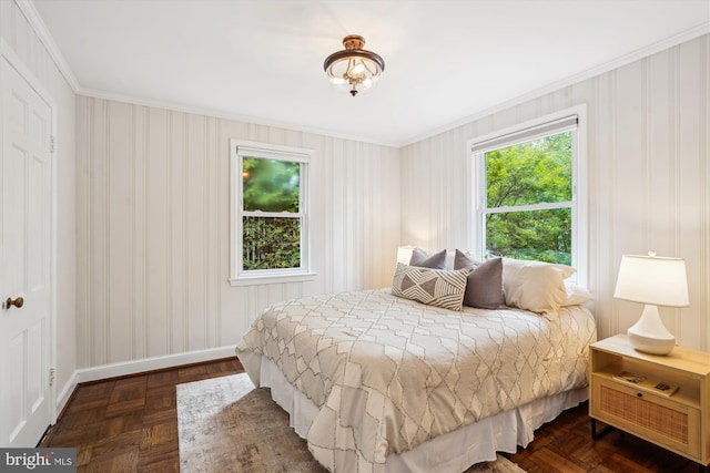 bedroom featuring crown molding, baseboards, and wallpapered walls