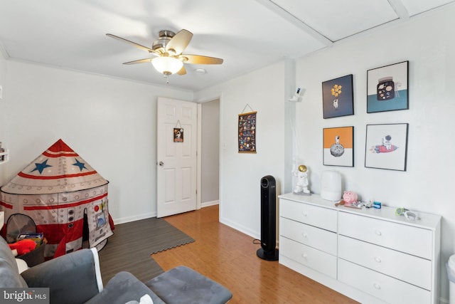 sitting room featuring wood finished floors, baseboards, and ceiling fan