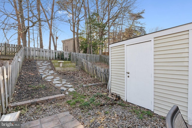 view of yard featuring a storage shed, an outdoor structure, and a fenced backyard