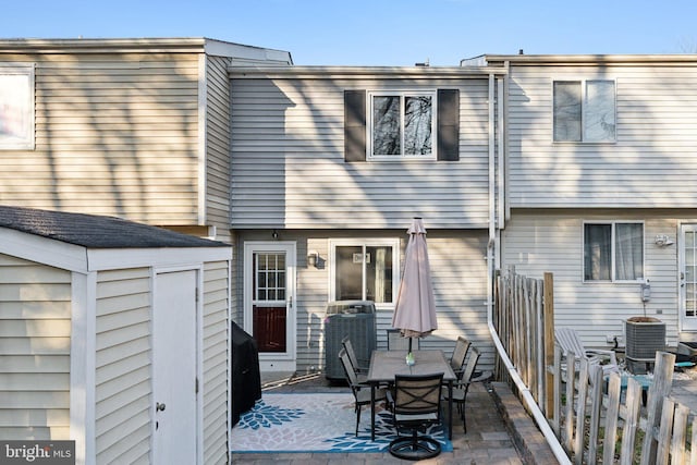 rear view of house with a patio area, cooling unit, and outdoor dining area