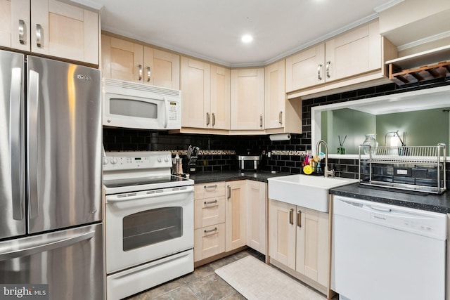 kitchen with white appliances, dark countertops, tasteful backsplash, and a sink