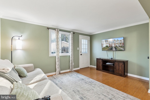 unfurnished living room with baseboards, wood finished floors, and ornamental molding