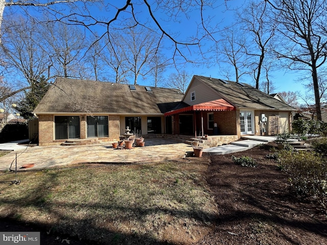 back of house with entry steps, a patio, french doors, and brick siding