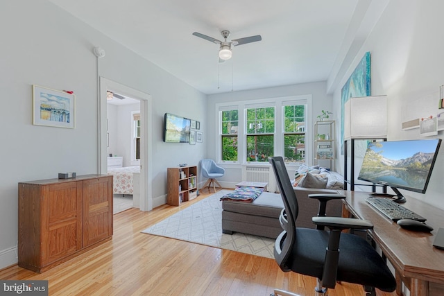 office space featuring baseboards, light wood-type flooring, and a ceiling fan