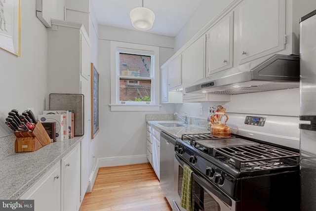 kitchen with light wood-type flooring, under cabinet range hood, a sink, range with gas cooktop, and dishwasher