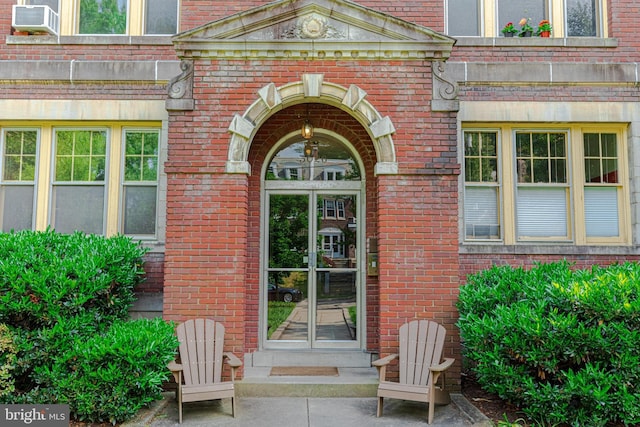 entrance to property featuring cooling unit and brick siding