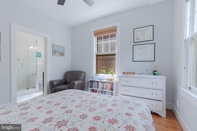 bedroom featuring connected bathroom, baseboards, light wood-style floors, and ceiling fan