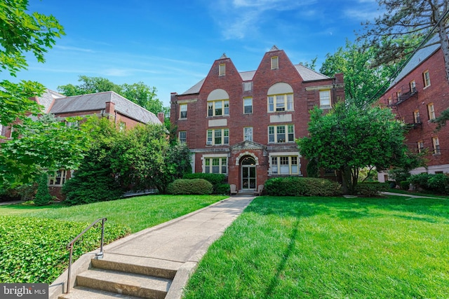 view of front facade featuring a front yard and brick siding