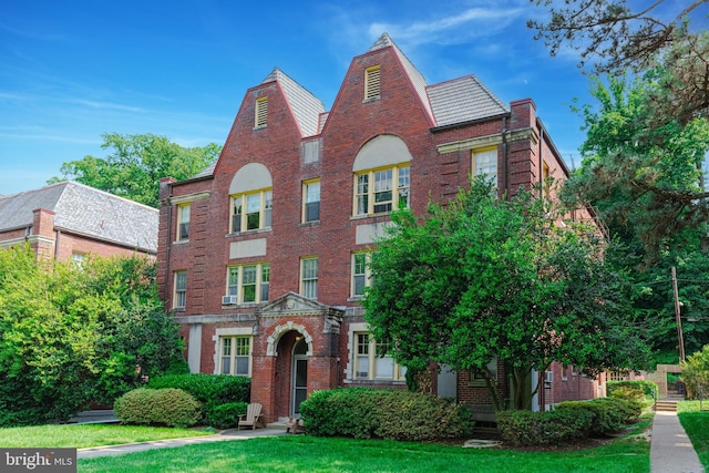 view of front of property with brick siding and a front lawn