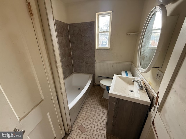 full bath with vanity, a wainscoted wall, a baseboard radiator, tile patterned flooring, and toilet