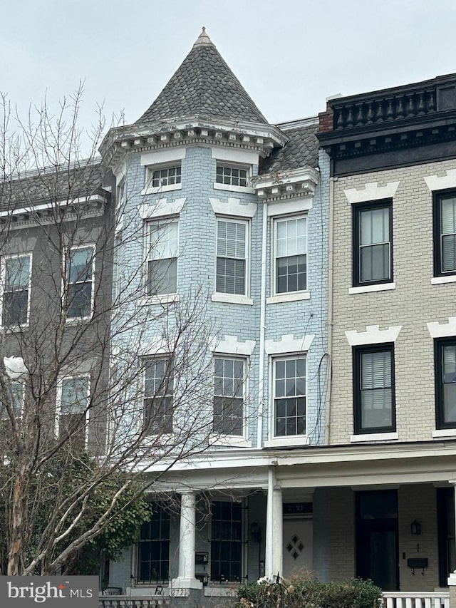 view of front of home with a porch and brick siding