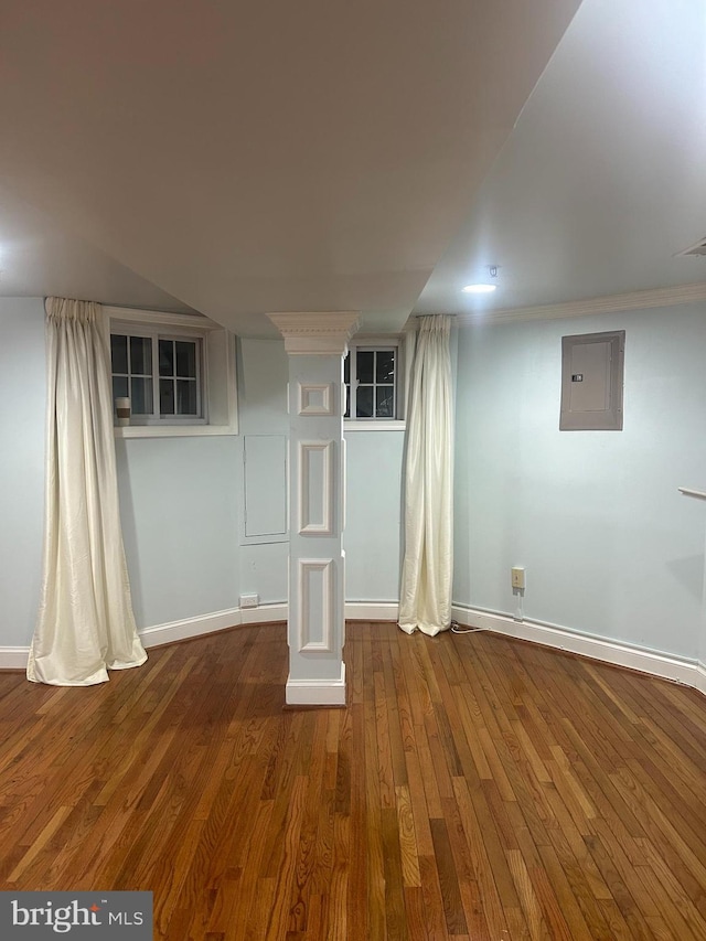 finished basement featuring electric panel, baseboards, and wood finished floors