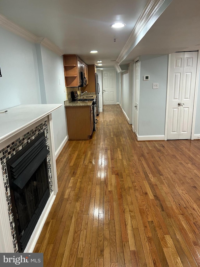 kitchen featuring dark wood-style floors, baseboards, open shelves, appliances with stainless steel finishes, and crown molding