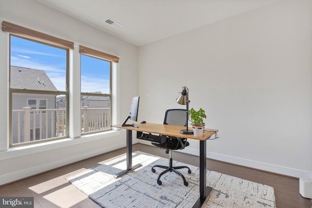 office with visible vents, baseboards, and wood finished floors