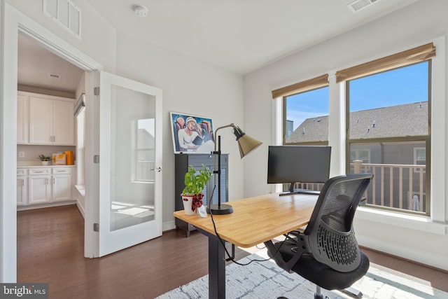 office area with visible vents, baseboards, and dark wood-style floors