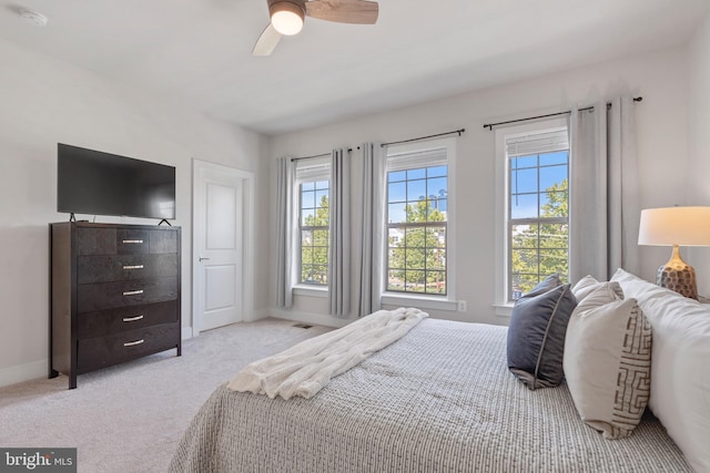 carpeted bedroom with ceiling fan and baseboards