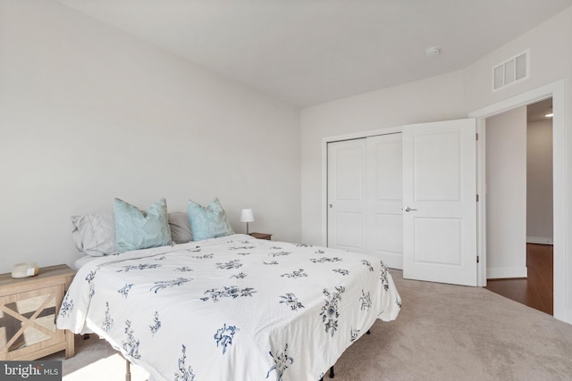 carpeted bedroom featuring a closet and visible vents