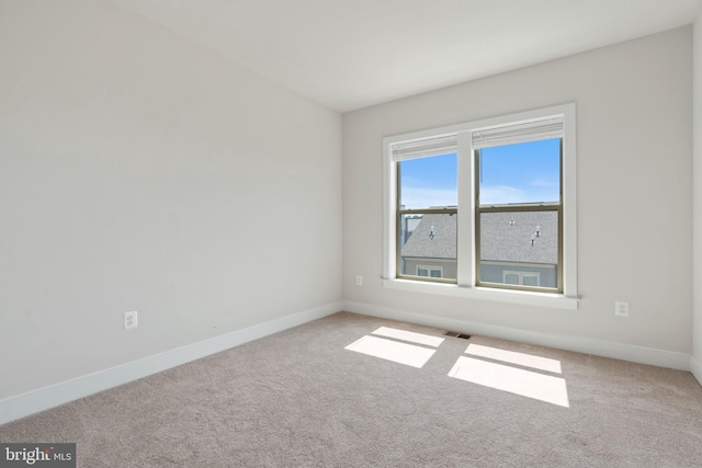 carpeted empty room with baseboards and visible vents