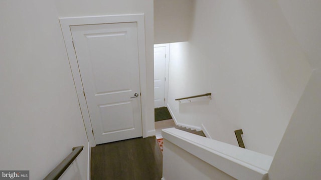 interior space with an upstairs landing and dark wood-style flooring