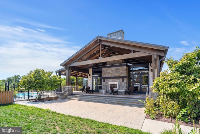 view of patio featuring a gazebo, a fenced in pool, an outdoor stone fireplace, and fence