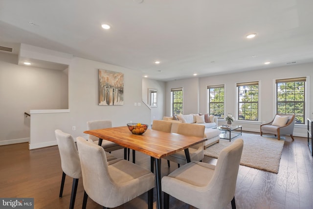 dining space with dark wood finished floors, recessed lighting, a healthy amount of sunlight, and visible vents