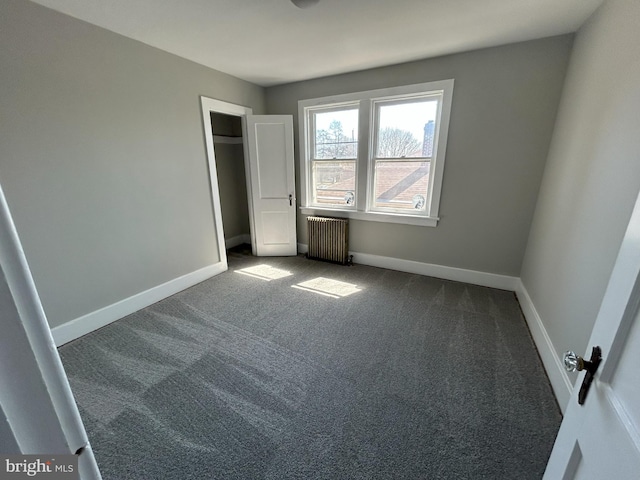 unfurnished bedroom featuring radiator, carpet, and baseboards